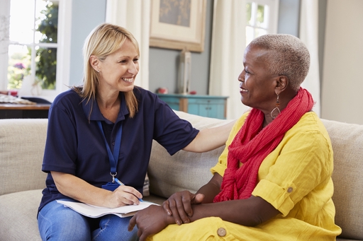 A live-in carer helping a patient with some paperwork.