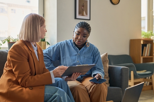 A live-inb carer sitting on a sofa with a client.