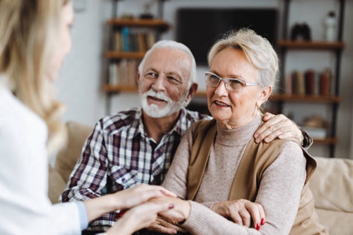 An elderly couple having a conversation with a live-in carer.