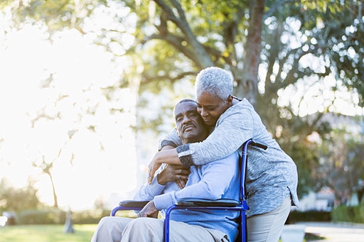 A elderly man outside with a live-in carer.