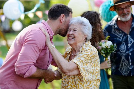 An elderly lady being greeted by a friend or ralative.