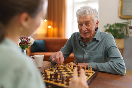 Live-in carer playing chess with a client